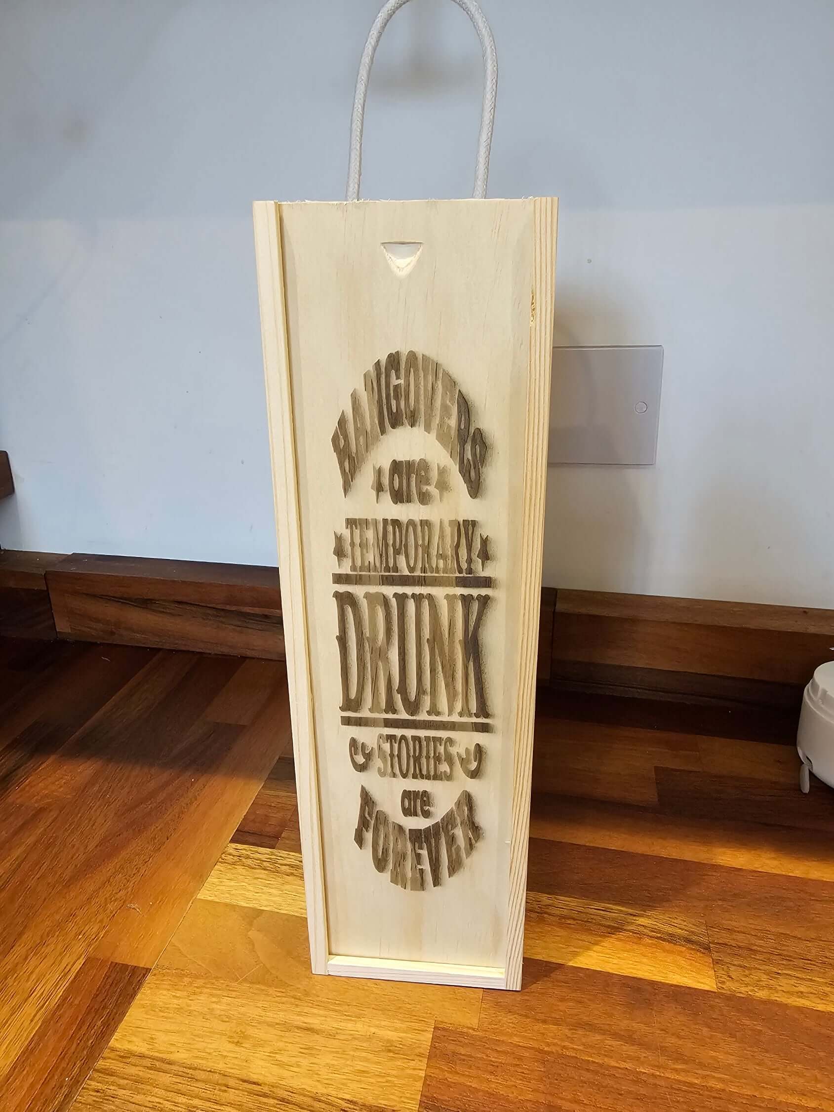 Engraved Wooden Wine Bottle Gift Box featuring humorous quote about hangovers and drinking.