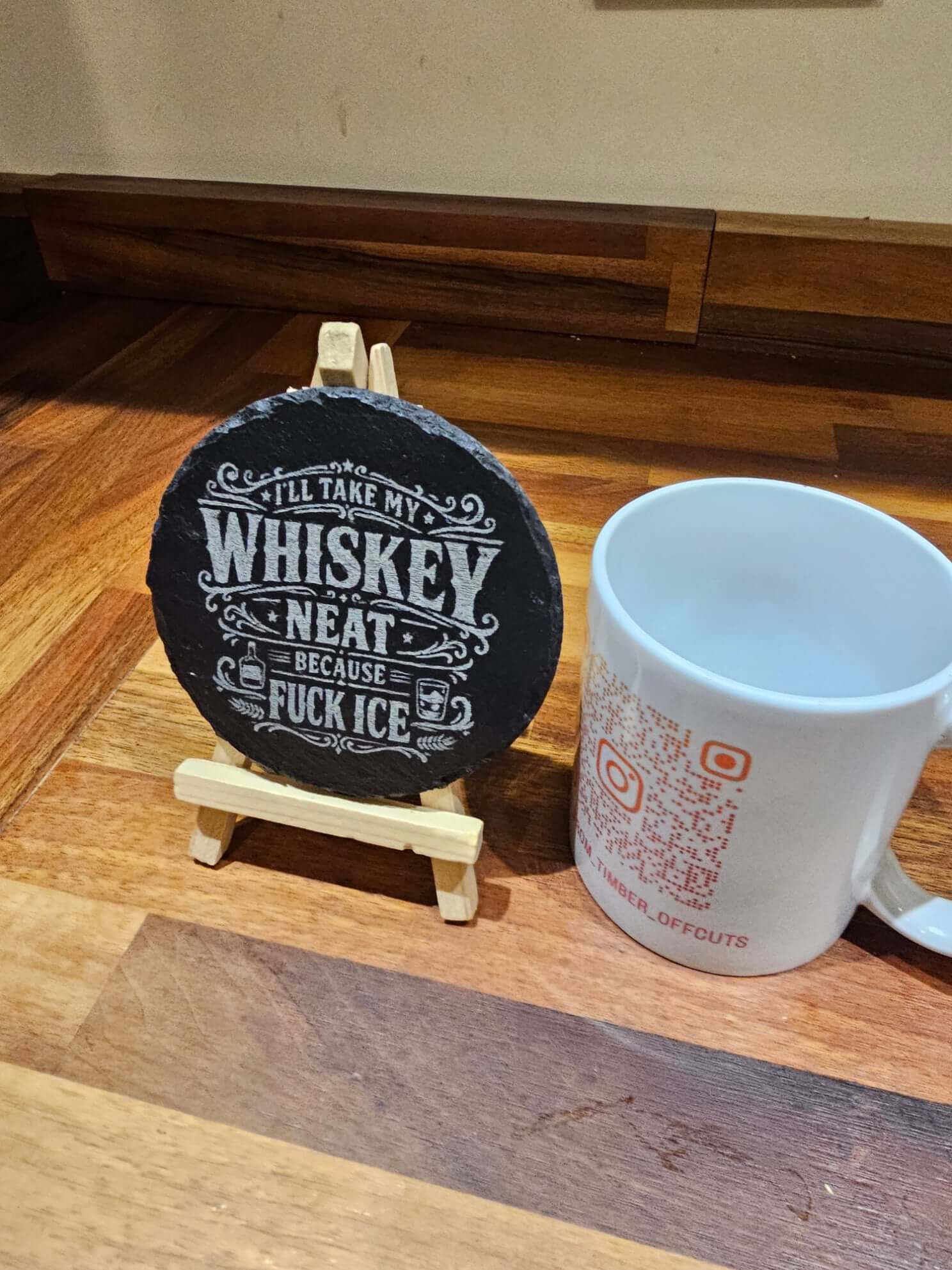 Slate Coasters Engraved Coaster with humorous whiskey saying "I'll take my whiskey neat because fuck ice" on display.