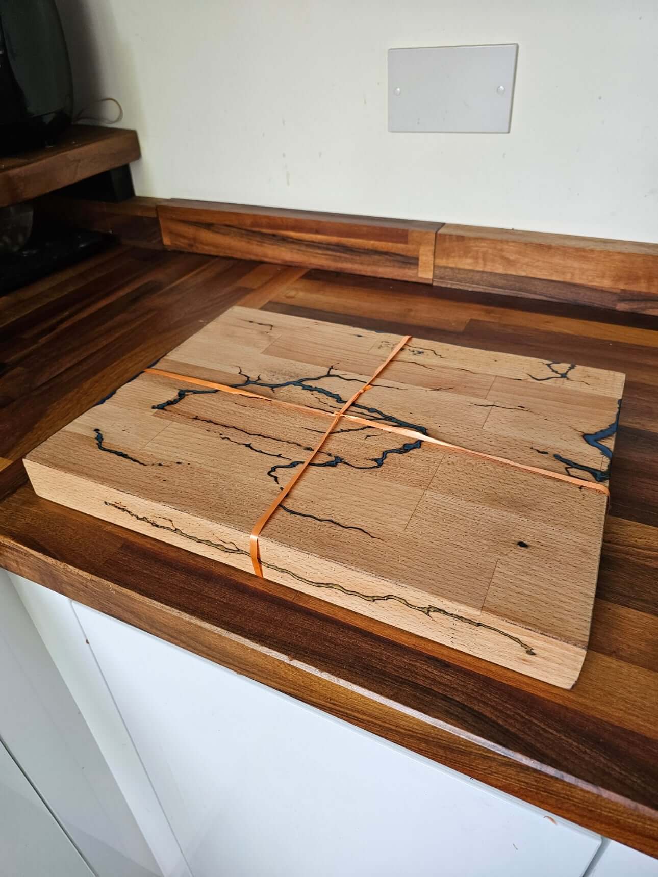 Handmade Multi-Colour Fractal Burn Chopping Board on a wooden countertop, showcasing stunning patterns.