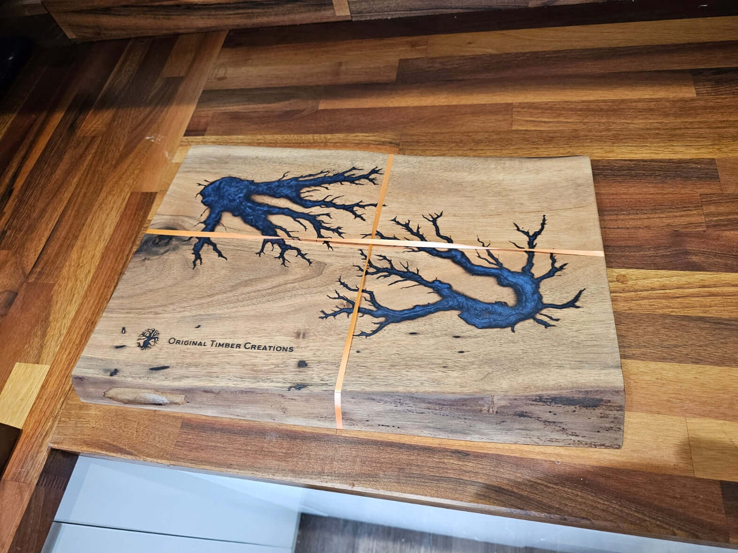 Handcrafted Resin Inlaid Wooden Board with deep blue resin inlays and natural wood grain by Original Timber Creations.