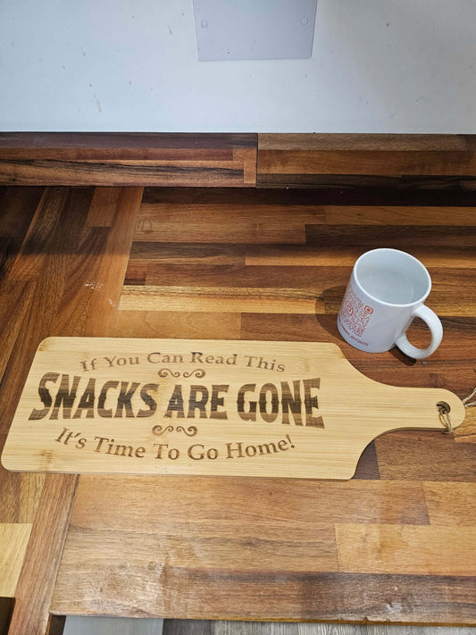 Funny Engraved Serving Board with the phrase 'If You Can Read This SNACKS ARE GONE It's Time To Go Home' on a wooden surface.