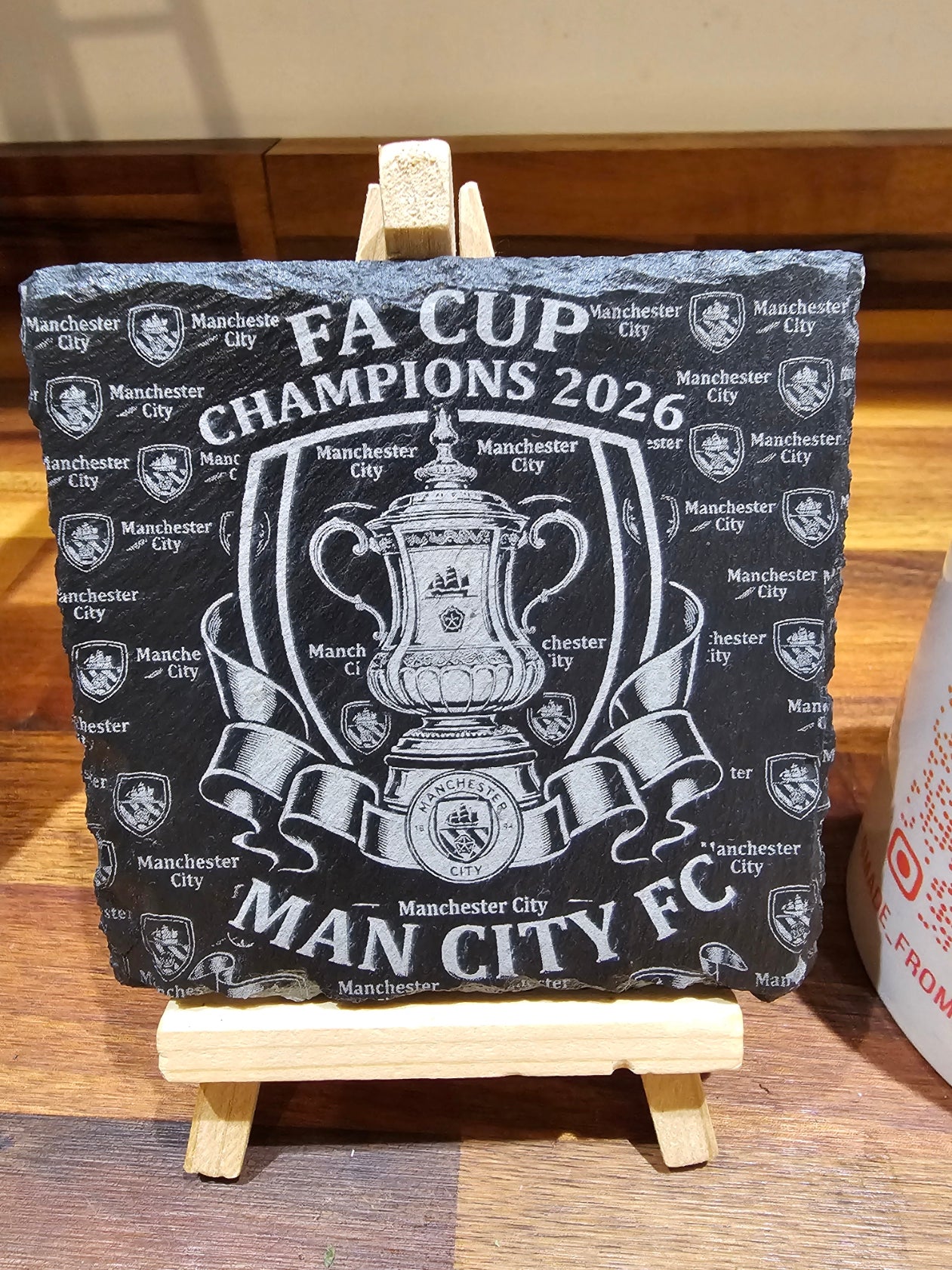 Manchester City FA Cup Champions 2026 Slate Coaster on a stand, featuring the FA Cup and team branding.