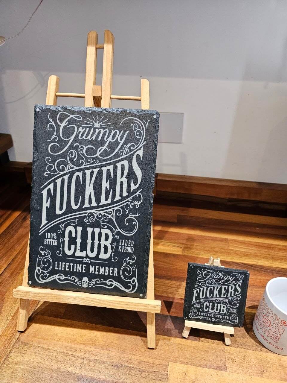 Slate plaque featuring the Grumpy Fuckers Club design, showcasing bold typography and decorative flourishes.