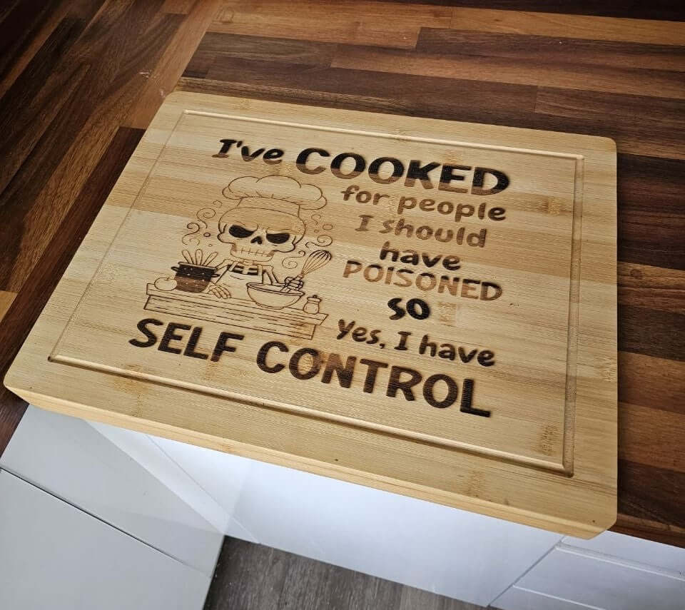 Funny Engraved Board with humorous quote about cooking and self-control on a bamboo chopping board.