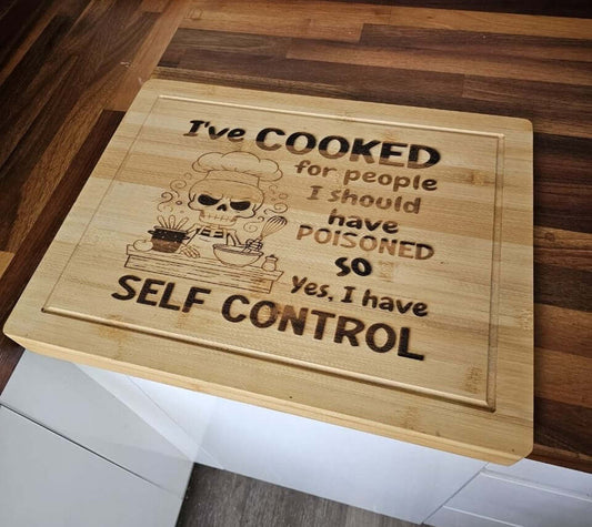 Funny Engraved Board with humorous quote about cooking and self-control on a bamboo chopping board.