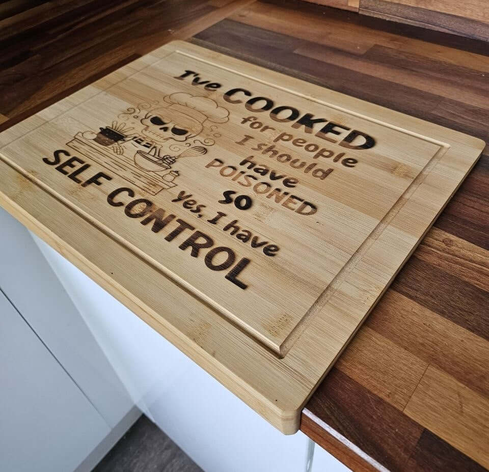 Funny Engraved Board with humorous quote about cooking and self control on a bamboo chopping board.