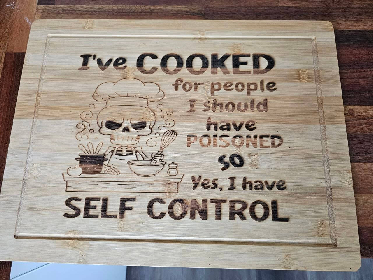 Funny Engraved Board featuring humorous quote about cooking and self-control on bamboo chopping board.